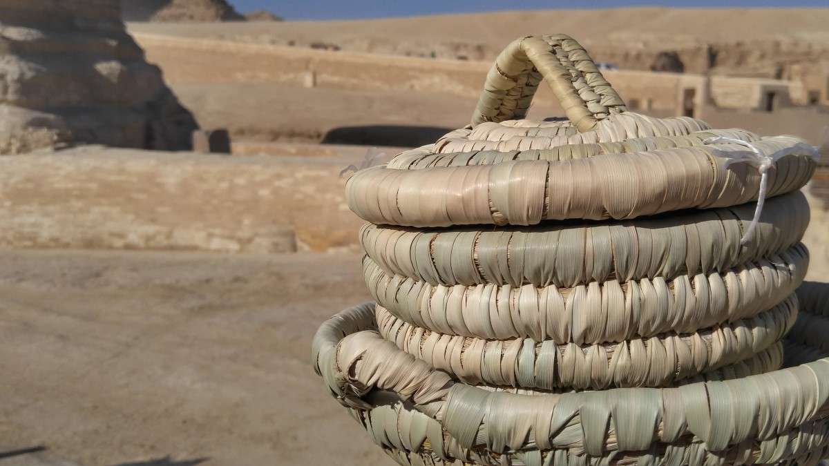 grass bread basket with lid sitting near open desert field